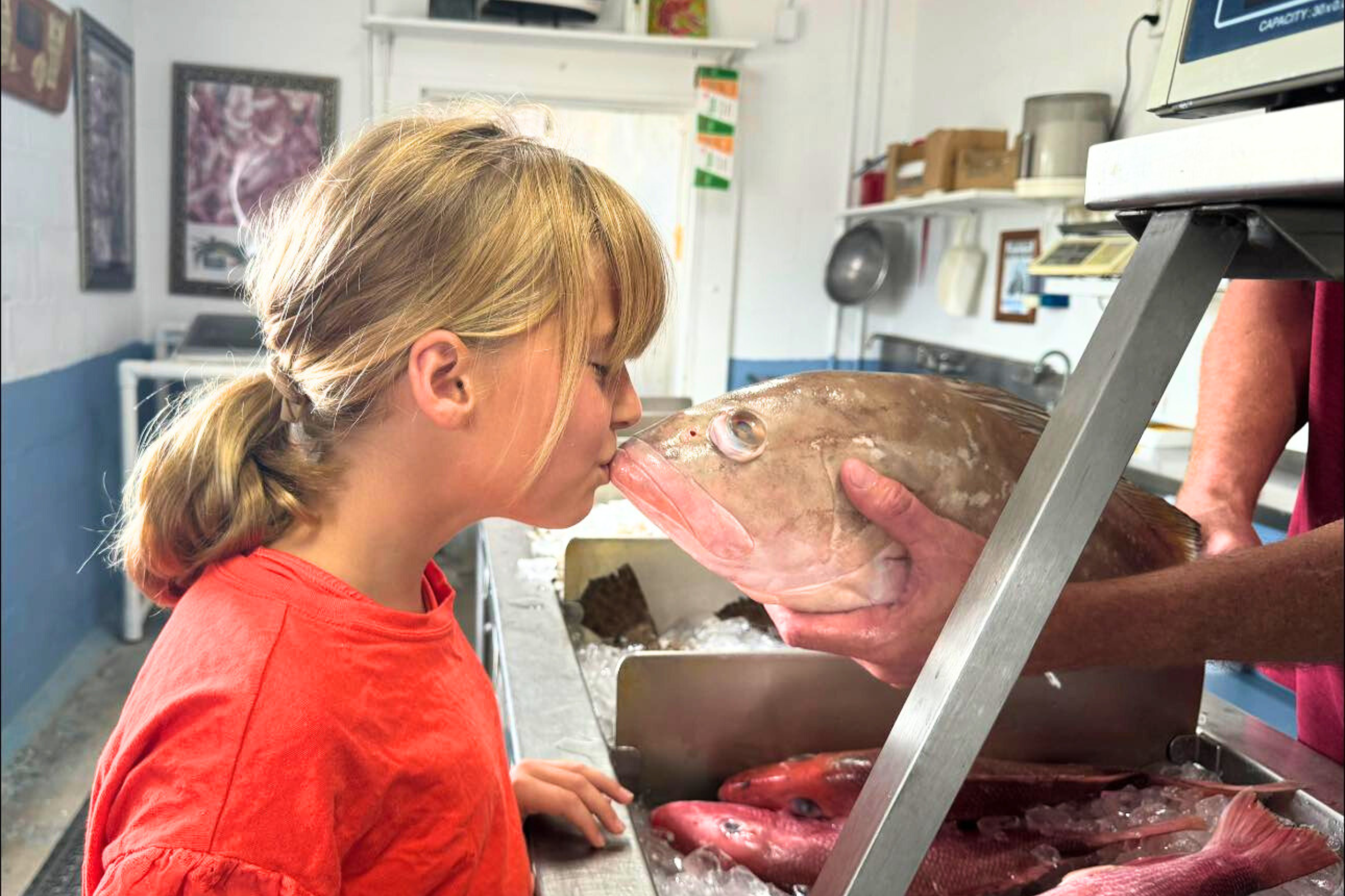girl kissing fish caught off the gulf coast of alabama