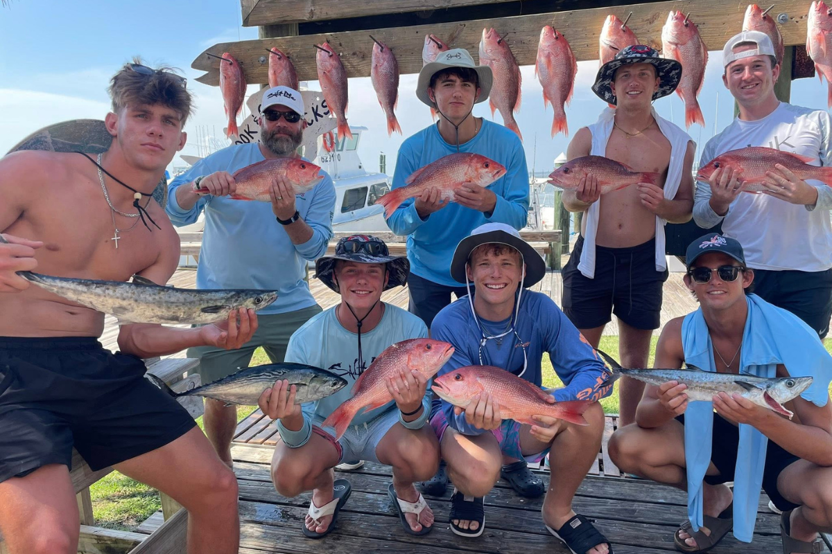 large group of guys holding red snapper caught off coast of Dauphin Island and Fort Morgan