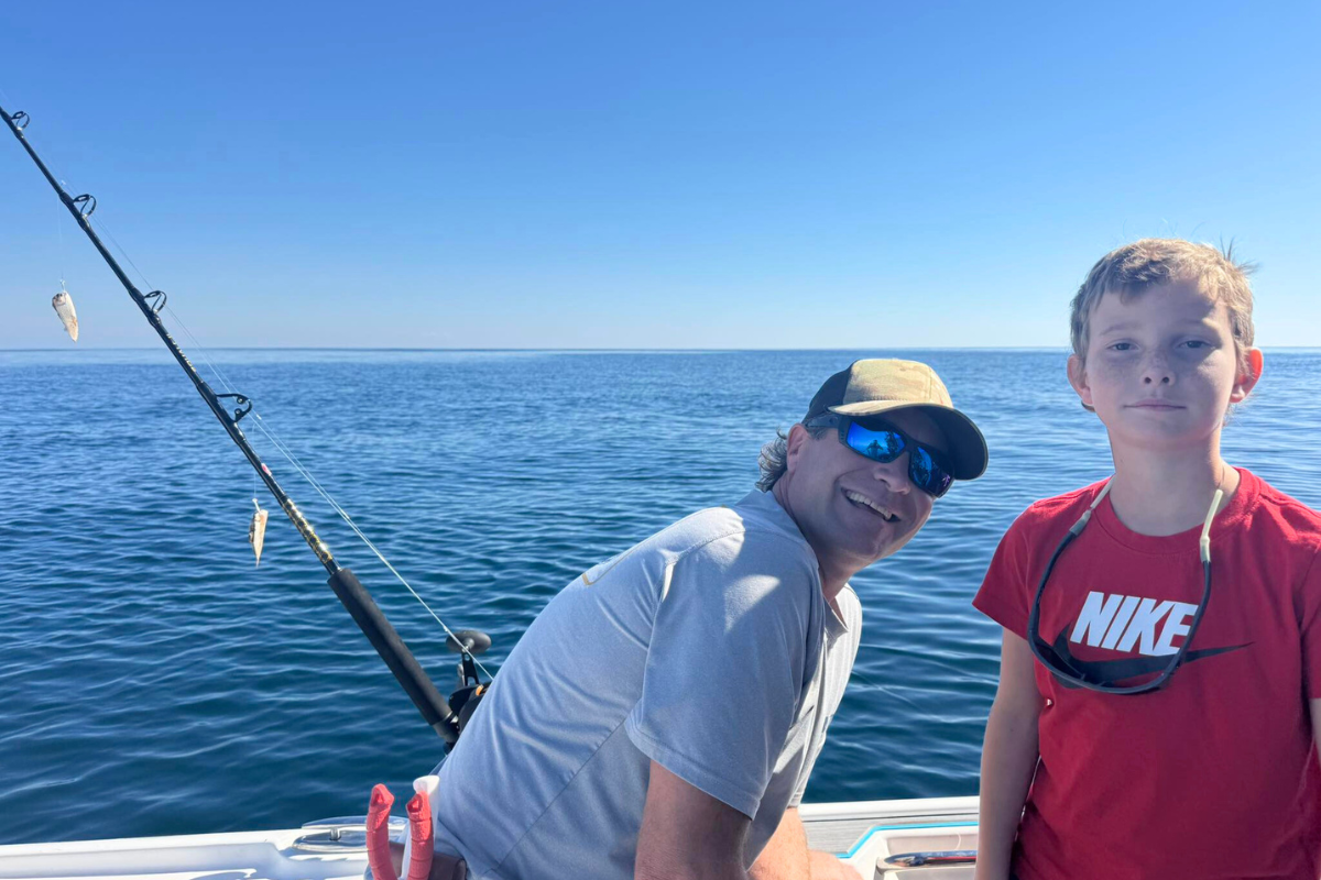 father and son fishing aboard private offshore fishing trip in the Gulf of America