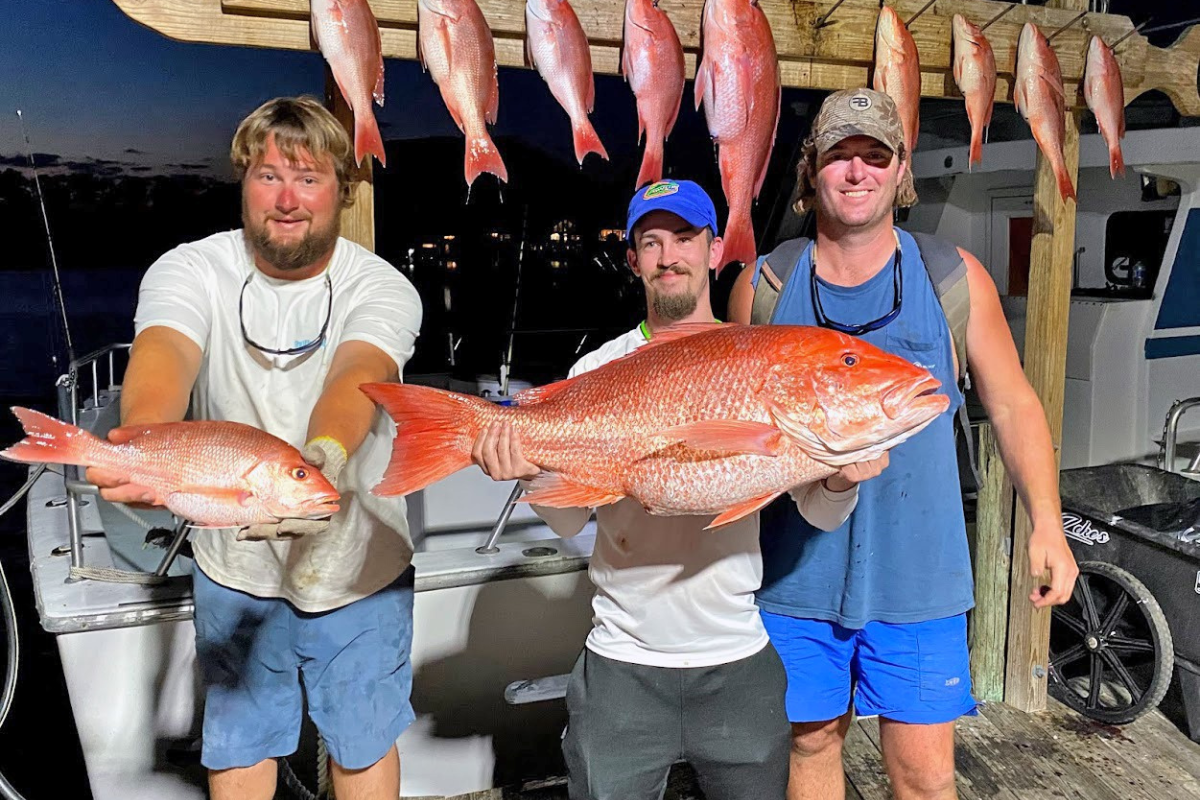 large red snapper and everybody having fun back at the dock after a full day of fishing on the Alabama gulf coast