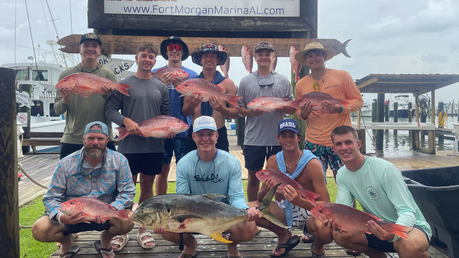 large group of boys in town for a baseball tournament show off red snapper caught offshore fishing out of Fort Morgan, Alabama