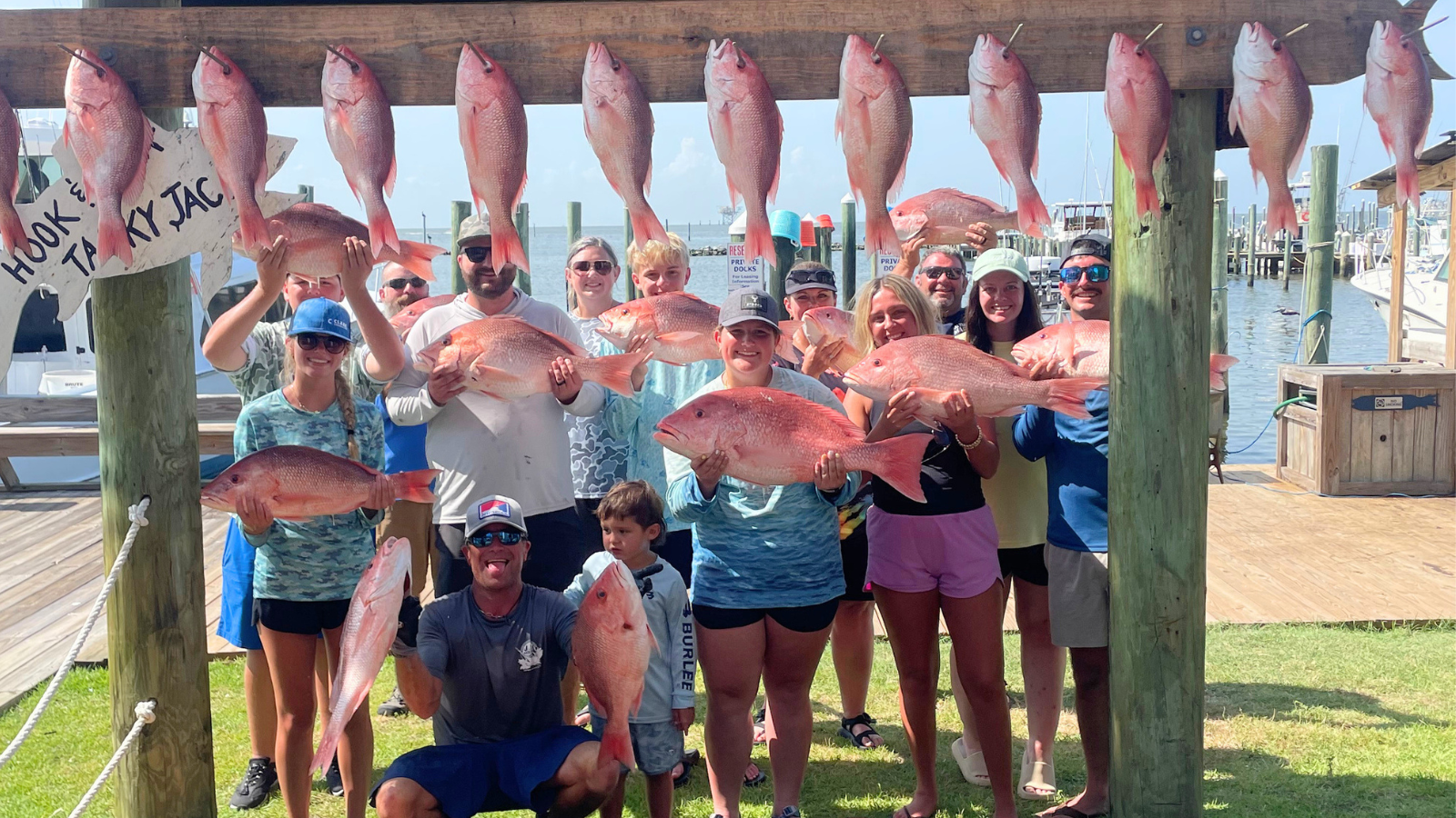 large family group at fort morgan marina holding red snapper caught aboard offshore fishing charter in gulf of america